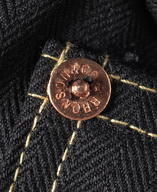 Black tour jacket button closure with round copper-toned snap detail