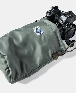 Olive nylon chalk bag with woven logo patch on front and carry strap attached