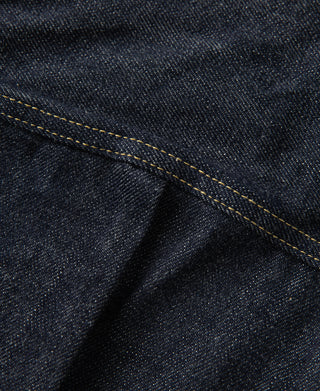 Indigo denim jacket seam detail with yellow topstitching along the edge