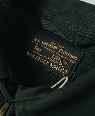 Dark green jacket interior care label with gold text and hanging tag