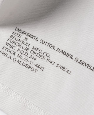White cotton tank top fabric with printed label text near hem edge
