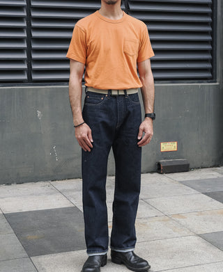 Orange crewneck pocket t-shirt worn with dark jeans.