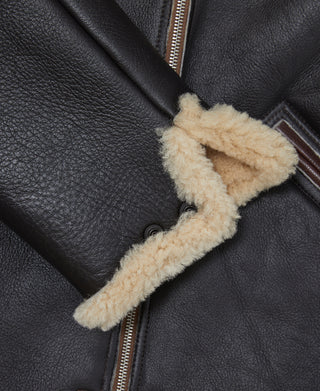 Dark leather flight jacket front with cream shearling storm flap and zipper