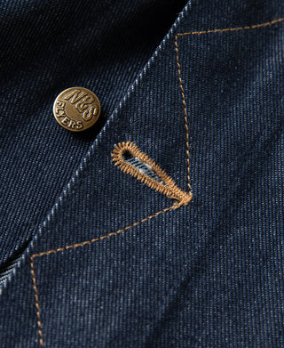 Indigo denim jacket metal button close-up on seam, with N&S logo.
