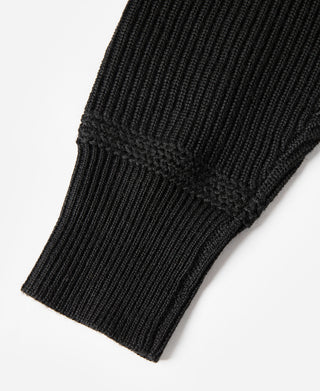Black wool sweater ribbed sleeve cuff and knit texture detail