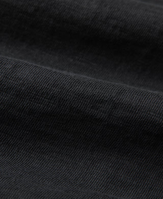 Black henley T-shirt fabric closeup with fine knit texture