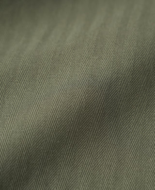 Olive HBT utility jacket fabric close-up with herringbone weave texture