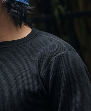 Black waffle-knit crewneck top with close-up of shoulder and neckline