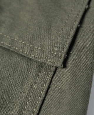 Olive fatigue utility shorts fabric close-up with reinforced seam and stitching