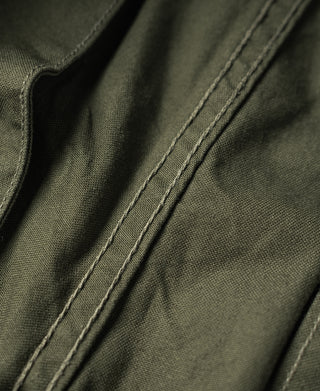 Olive pants fabric close-up with double-stitched seam detail