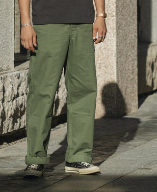 Olive wide-leg trousers on model with cuffed hems and side hand pockets