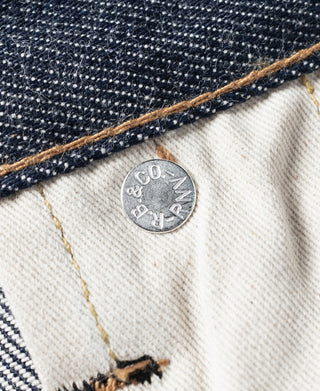 Selvedge denim jeans interior waistband with light lining and a stamped metal button