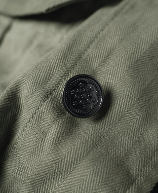Olive fatigue jacket fabric with round black button detail