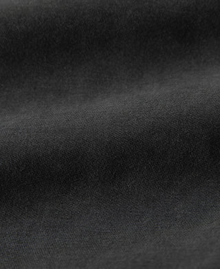 Black moleskin cossack jacket fabric close-up with dense textured weave
