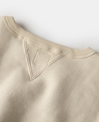 Apricot knit sweater with ribbed crew neck and V-inset at the collar