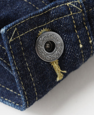 Indigo denim jacket cuff corner with engraved metal snap and yellow stitching
