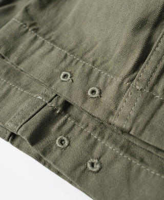 Olive utility pants waistband and buttoned closures close-up