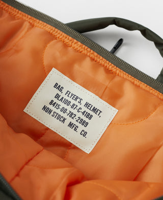 Helmet bag interior label on orange lining with gray zipper and open top