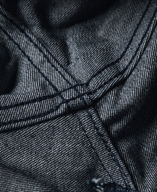 Dark navy denim close-up showing interior cross-stitching at seams