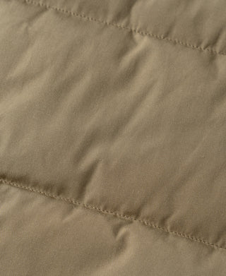 Khaki quilted padded vest fabric close-up with stitched quilting lines