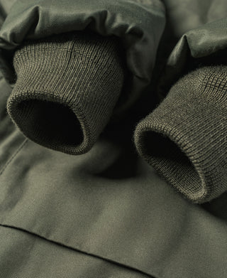 Olive ribbed knit cuffs on jacket lining, close-up fabric texture
