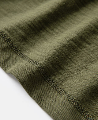 Green cotton t-shirt hem and side seam detail with stitched edge