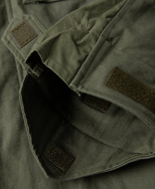 Olive field jacket hem with inner lining, snap tab, and utility pocket