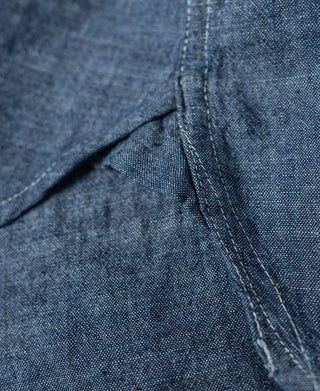 Blue chambray work shirt side seam with split fabric panel and stitching