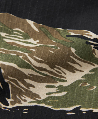 Tiger-camo shorts fabric close-up in green, black, and tan patterns