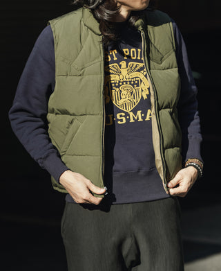 Olive quilted padded vest front view worn over a graphic hoodie and dark pants