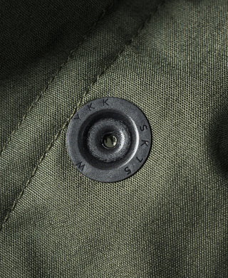 Olive M-65 parka round metal snap button closure on textured fabric