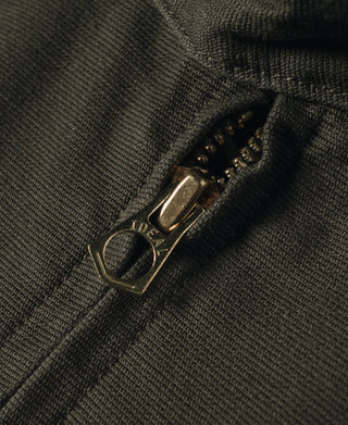 Olive jacket zipper pull and metal zipper with stitched placket detail