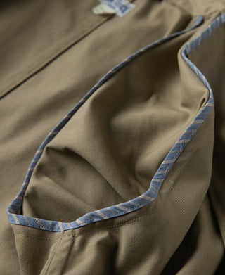 Khaki all-weather trench coat interior with blue-trimmed pocket opening