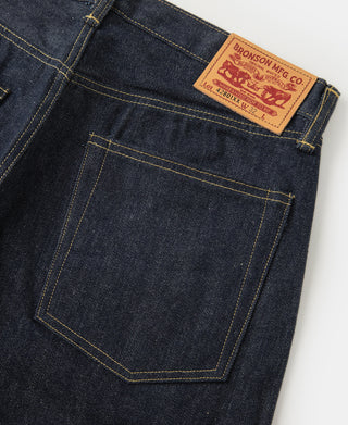 Indigo denim jeans back pocket with leather patch and bar-tack stitching