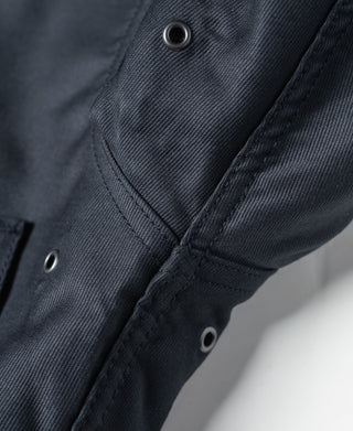 Navy deck jacket pocket flap with two grommet buttons and stitched seam