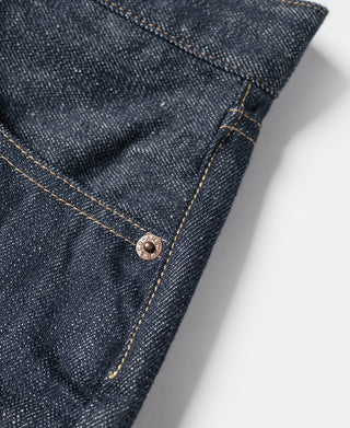 Dark blue denim jeans hem with copper rivet and tan contrast seam stitching
