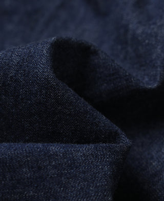 Indigo denim utility coverall jacket sleeve cuff and textured fabric close-up