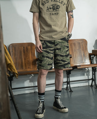 Camo cargo shorts with knee-length cut, front patch pockets, and button closure