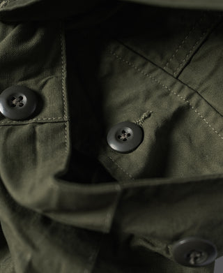 Olive fatigue pants showing metal-tone buttons and interior pocket opening