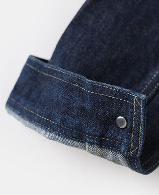 Indigo denim jacket cuff with metal snap and yellow bar-tack stitching