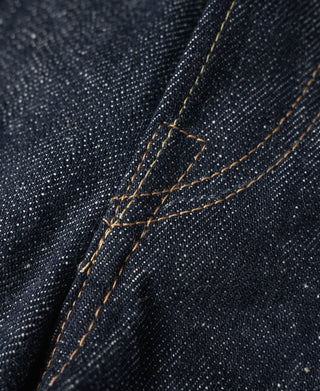 Dark denim jeans with tan topstitching and visible seam construction details