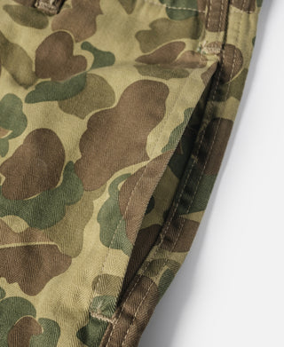 Camouflage cotton pants, side seam and stitched hem detail in green, tan, and brown.
