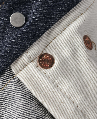 Indigo selvedge denim jeans—copper rivet button detail and contrast stitched pocket seam