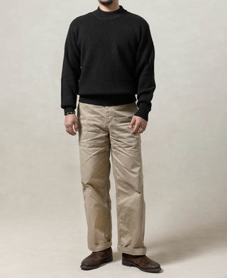 Black wool crewneck sweater worn on model, full-body view with ribbed trim