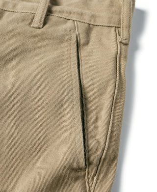 Khaki pants leg close-up with side seam and stitched pocket edge.
