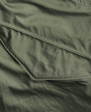 Olive M-65 parka flap pocket with stitched trim and angled seam lines