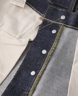 Selvedge denim jeans detail view of indigo waistband with metal button closure
