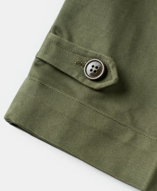Olive back hem detail with fabric tab and metal-toned button.