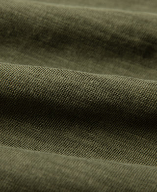 Green cotton jersey fabric close-up with fine textured weave
