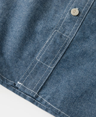 Blue chambray work shirt chest pocket with topstitching and round button